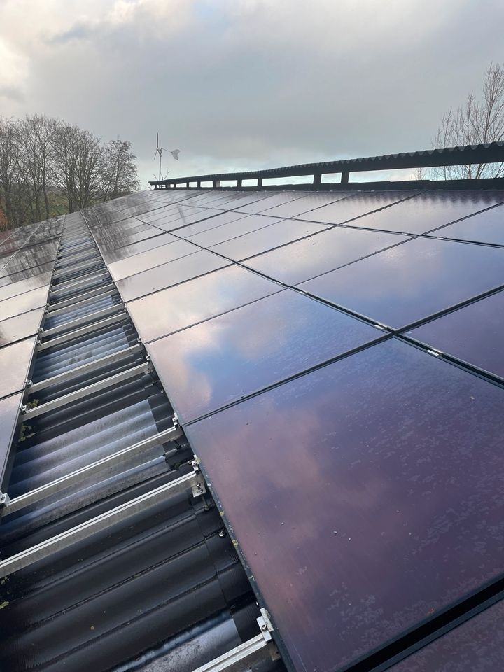 Verschmutzte Solarmodule auf einem Dach vor der Reinigung, mit Staub- und Schmutzablagerungen