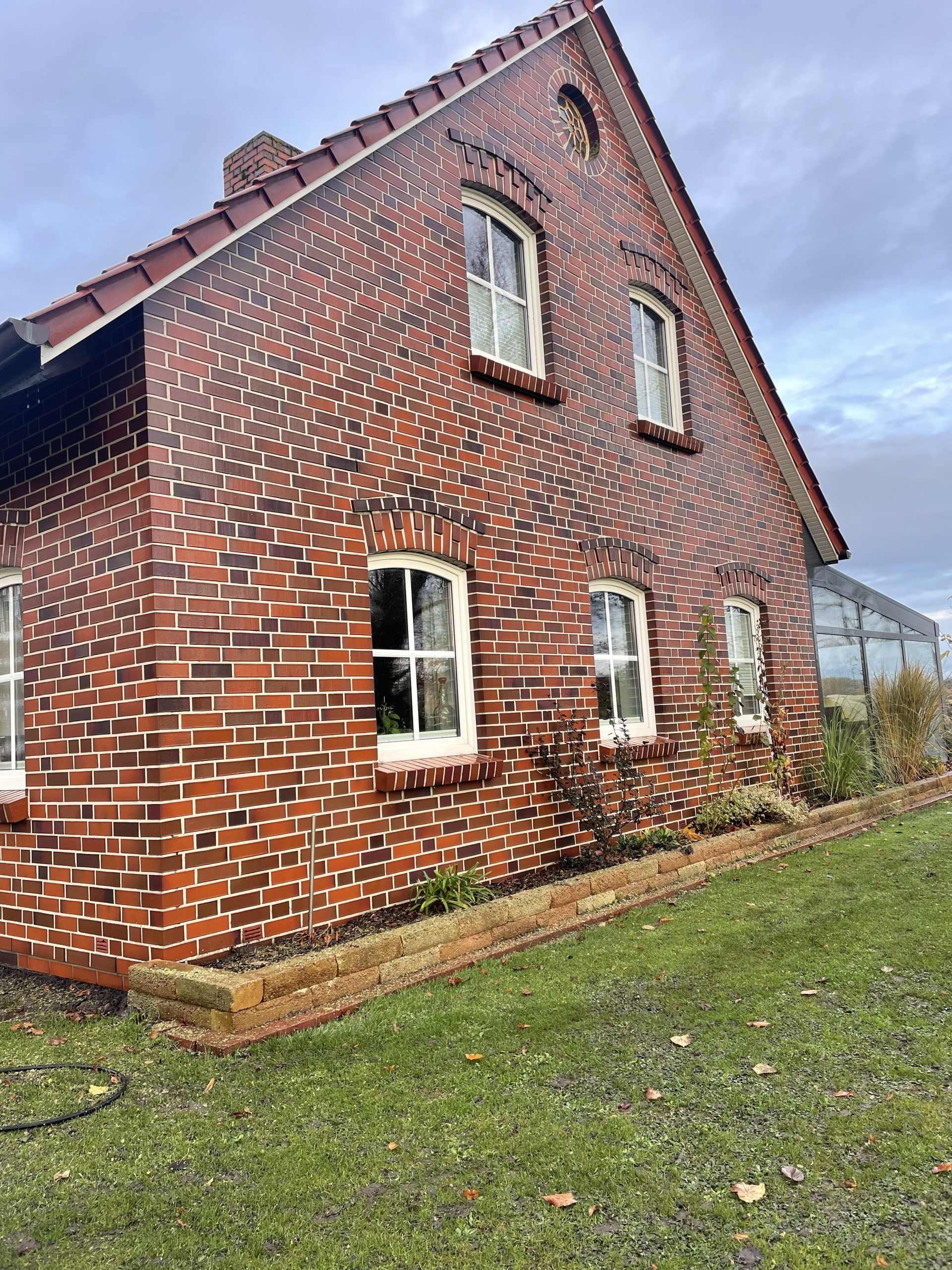 Ziegelhausfassade nach der Reinigung, sauber und frei von Algen und Flechten, mit einer klaren und gepflegten Optik der Ziegel und Fugen